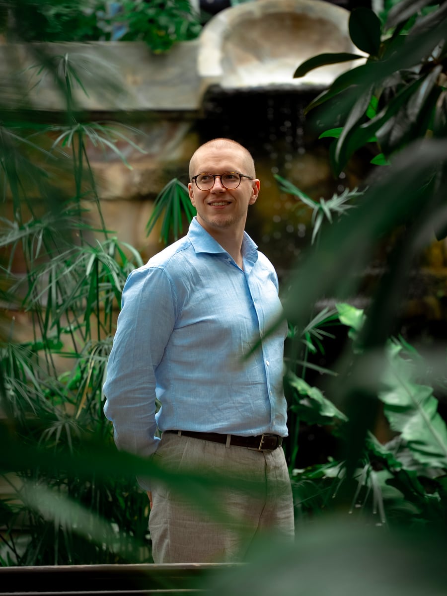 Eero Siivola standing among green foliage